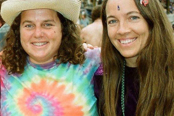 Stacy Raye and Heather Mitchell, founding directors of Monkey Business Camp, near 1999 when the camp was founded. Stacy wears a straw cowboy hat and tie dye t-shirt, Heather has a butterfly clip in her long hair and a bindhi on her forehead