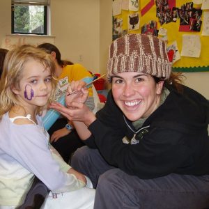 Counselor Jenny doing facepainting for a camper at Winter Camp in Berkeley